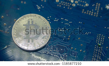 a bitcoin coin on blue electronic circuit