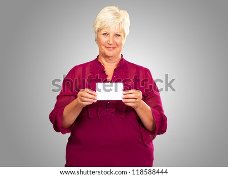 Old Woman Showing  Paper On Gray Background
