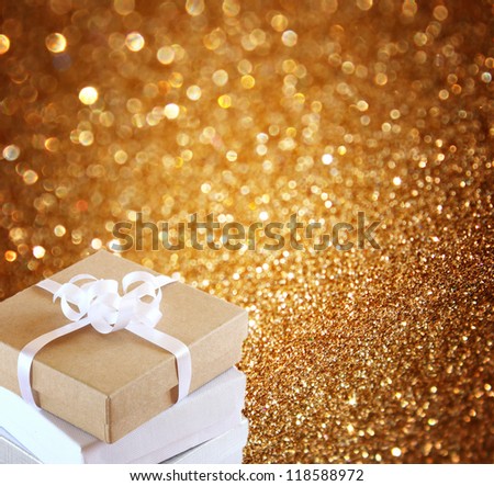 Christmas gift box on background of defocused golden lights.
