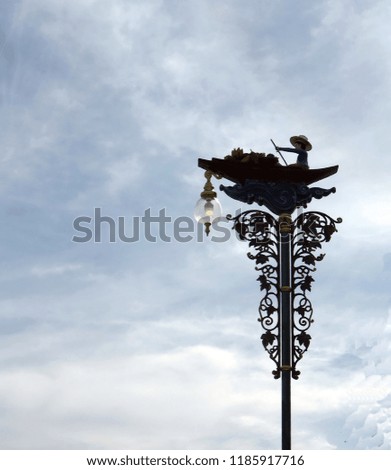 The floating market boat image is on the electric lamp post in silhouette as the symbol of the floating market place,Damnoen Saduak,Thailand.