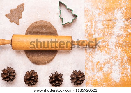 Making cookies in a shape of a Christmas tree on a wooden table.