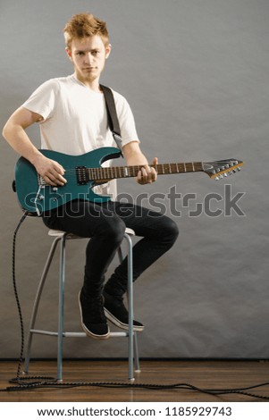 Man playing on electric guitar during gig. Musical instrument. Teenage boy having music hobby.