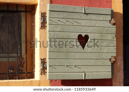 Wooden shutters on windows. Love and peace concept. Heart sign