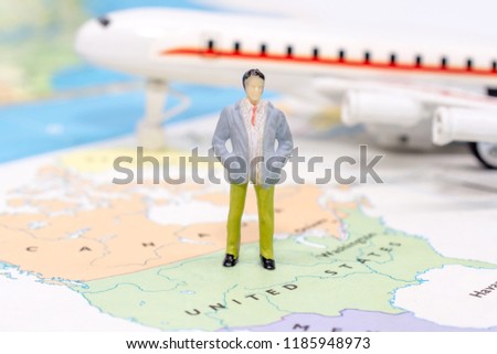 Miniature people, businessman standing on map American 