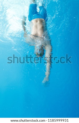 Photo on top of young athlete man swimming on back in swimming pool