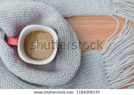 Modern holidays, Closeup picture of warm scarf with cup of hot coffee on wooden, About winter. Royalty-Free Stock Photo #1186008145