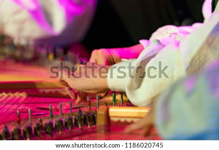 Hand playing on kokle a Latvian plucked string instrument belonging to the Baltic box zither family. Royalty-Free Stock Photo #1186020745
