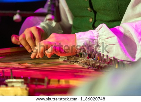Hand playing on kokle a Latvian plucked string instrument belonging to the Baltic box zither family. Royalty-Free Stock Photo #1186020748