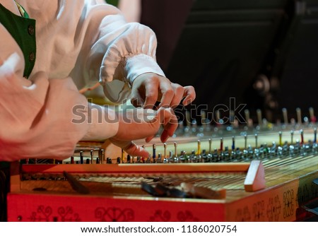 Hand playing on kokle a Latvian plucked string instrument belonging to the Baltic box zither family. Royalty-Free Stock Photo #1186020754