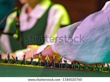 Hand playing on kokle a Latvian plucked string instrument belonging to the Baltic box zither family. Royalty-Free Stock Photo #1186020760