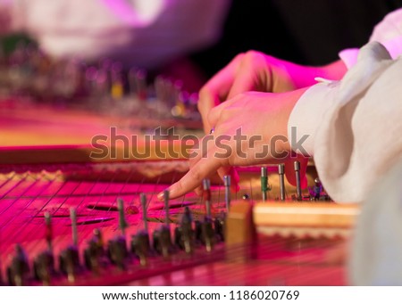 Hand playing on kokle a Latvian plucked string instrument belonging to the Baltic box zither family. Royalty-Free Stock Photo #1186020769