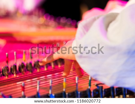 Hand playing on kokle a Latvian plucked string instrument belonging to the Baltic box zither family. Royalty-Free Stock Photo #1186020772