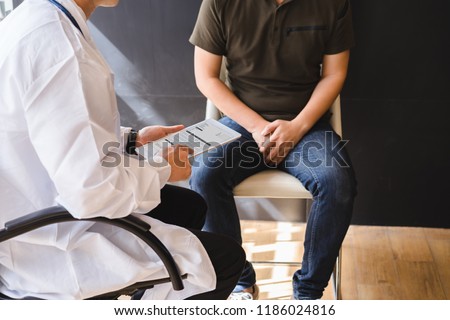 Male doctor and testicular cancer patient are discussing about testicular cancer test report. Testicular cancer and prostate cancer concept. Royalty-Free Stock Photo #1186024816