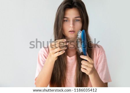 Young woman is very upset because of hair loss