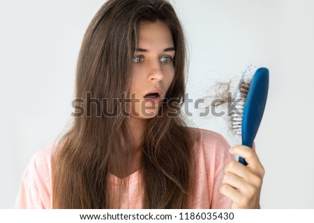 Young woman is very upset because of hair loss Royalty-Free Stock Photo #1186035430