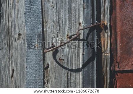 Close up of old iron rusty handle and hasp on the old weathered wooden door