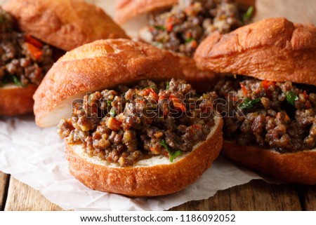 South African food: deep-fried vetkoek sandwich with meat curry close-up on the table. horizontal
