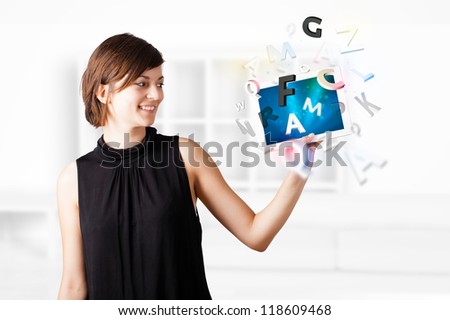 Beautiful young woman looking at modern tablet with alphabet