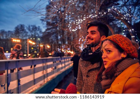 Couple Standing Beside Ice Rink Outdoors