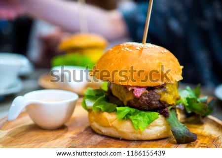 Eating favorite hamburger for dinner. slicing hamburger with french fries and ketchup as side dish. beautiful picture, hamburger perfect to use as poster. beautiful hamburger. 