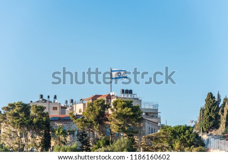 Israeli National flag waving on the top of rooftop in Mount of Olive in Jerusalem, Israel