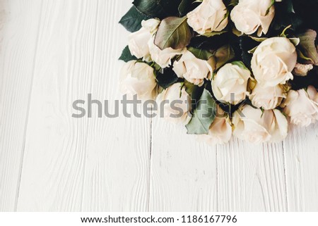 White roses on wooden background, space for text. Floral greeting card mockup. Wedding invitation or happy mother day concept. Bouquet of white flowers. hello spring