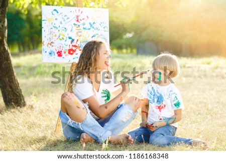 Happy family drawing a picture. Young mother having fun with her children