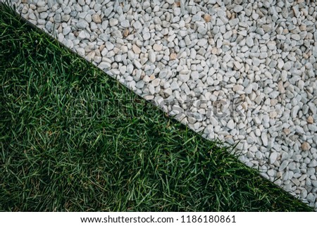 Abstract diagonal composition with green grass field and white stones surface texture, top view