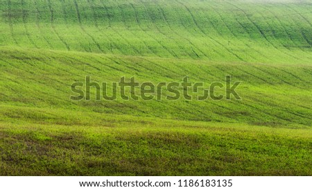 green field cultivated with tractor signs