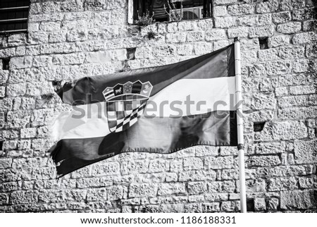 Croatian flag on stone background. Symbolic object. Black and white photo.