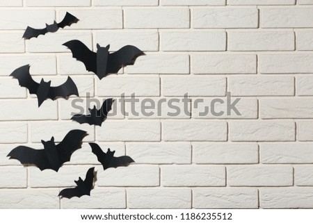 Halloween paper bats on white brick wall background