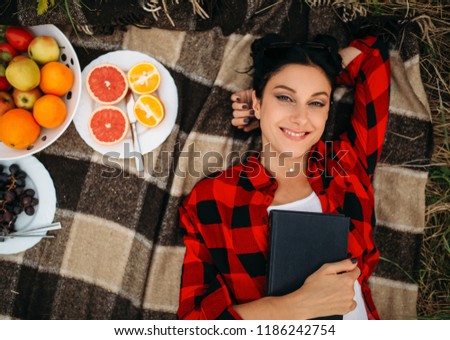 Woman lies on plaid, top view, picnic in field