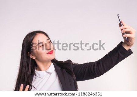 Technology, smartphone and people concept - Happy young asian woman making selfie over white background