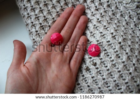 Pink earings on girls hand.