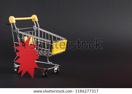 Red sale tag with shopping cart on black background