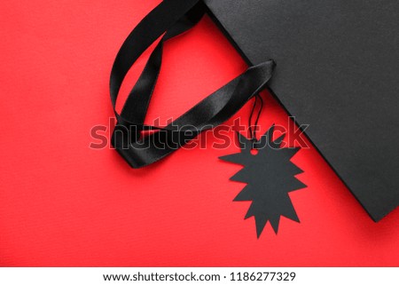 Black sale tag with paper bag on red background