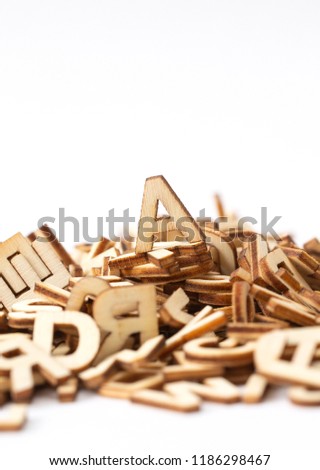 A letter on top of a pile of wooden letters, isolated on white. Copy space.