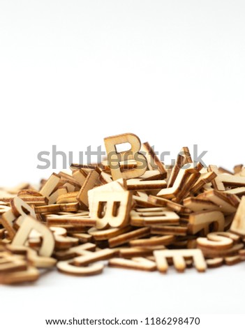B letter on top of a pile of wooden letters, isolated on white. Copy space.