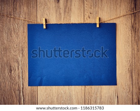 Blank for text on blue paper a wooden background. Letter on the clothespins. Vintage wooden texture. Free space. Copy Space