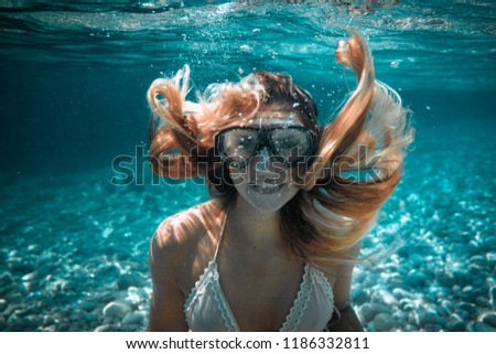 Beautiful woman with long hair underwater portrait in the tropical sea