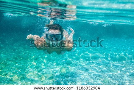 Woman with mask underwater snorkeling in the clear tropical water