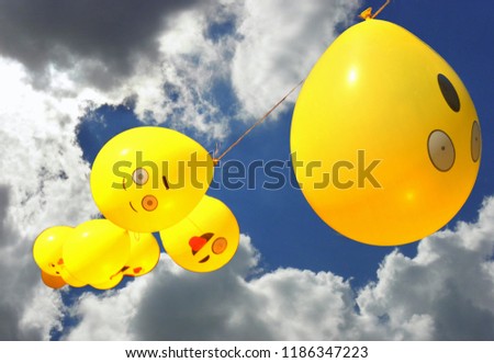 Yellow balloons with emoticons and sky background.
