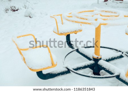 Snow-covered children's carousels.