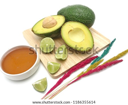 Whole and dissect of avocado lime with honey isolated on white background