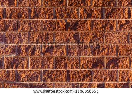 Wall of red brick, the facade of the building in the light of the evening sun. The texture of the material.