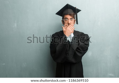 Young graduated man against a grunge wall with a copy space covering mouth, symbol of silence and repression, trying not to say anything