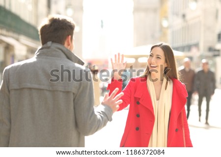 Two happy friends meeting and greeting in the street of a big city Royalty-Free Stock Photo #1186372084