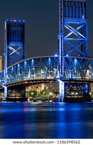 Main Street Bridge in Downtown Jacksonville, FL.  Cool blue lights on the bridge illuminate the dark night sky over a placid river.