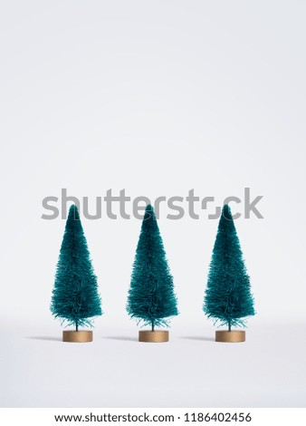 Small artificial Christmas trees on white background. Minimal style. Christmas and New Year concept.