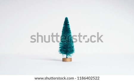 Small artificial Christmas tree on white background. Minimal style. Christmas and New Year concept.